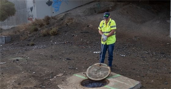County public works staff at a manhole lookng into sewer system